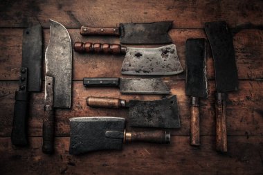 flat lay picture set of old rusty carbon steel clevers on top of wooden table