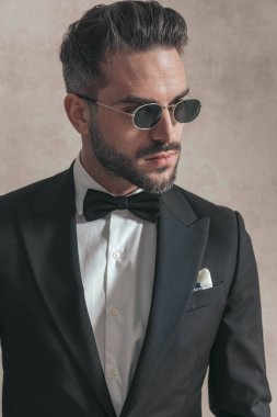 Sakallı, smokin giyen ve stüdyoda çalışmak isteyen seksi bir gencin portresi.