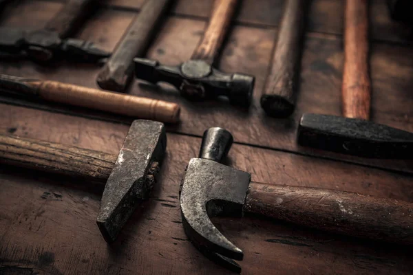 old rusty mallets equipment for carpentry, shoemaking, body work and geological industry in top of rustic old workbenc