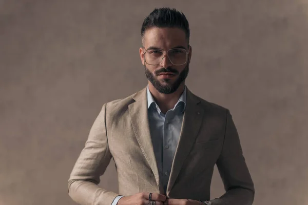 Portrait Handsome Businessman Unbuttoning Opening Suit Front Beige Background Studio — Zdjęcie stockowe