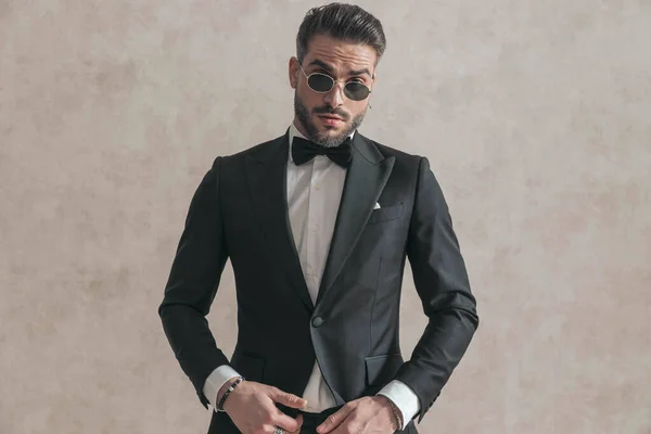 Portrait Elegant Businessman Black Tuxedo Wearing Sunglasses Posing Front Beige — Zdjęcie stockowe