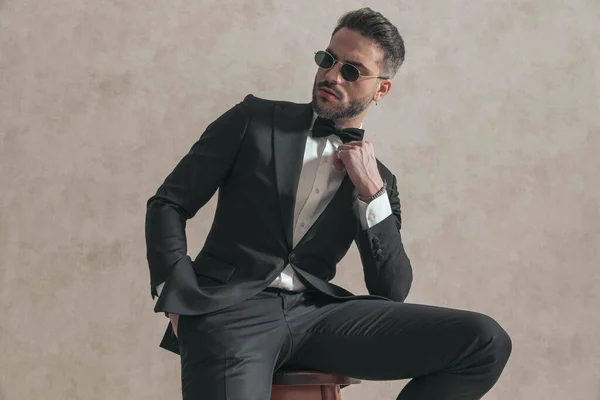 Portrait Cool Young Groom Black Tuxedo Looking Side Fixing Bowtie — Stockfoto