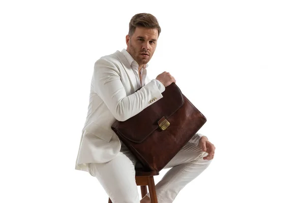 Selbstbewusst Sitzender Eleganter Mann Weißem Anzug Und Tasche Während Vor — Stockfoto