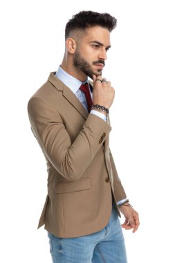 Düşünceli bir adamın el ele tutuşup stüdyoda beyaz arka planda poz verirken düşünmesi.