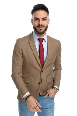 Mavi kot pantolon giyen, el ele tutuşan ve stüdyoda beyaz arka planda gülümseyen yakışıklı bir gencin portresi.