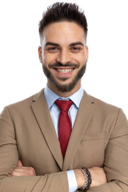 Kırmızı kravatlı mutlu genç iş adamı stüdyoda beyaz arka planda poz verirken gülümsüyor.