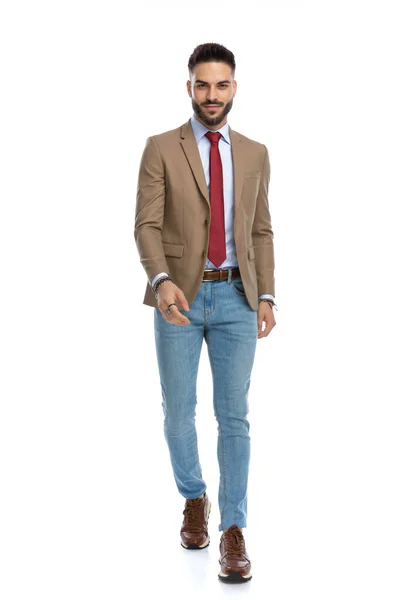 幸せな男です赤いネクタイと髭はセクシーさとスタジオで白い背景の前を歩く — ストック写真