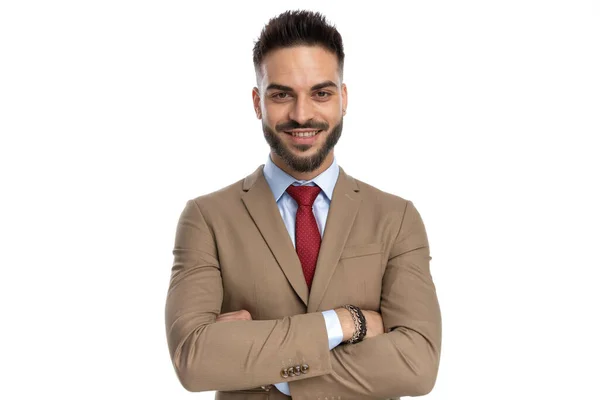幸せな実業家の肖像画で赤いネクタイが腕を交差しスタジオで白い背景で笑っています — ストック写真