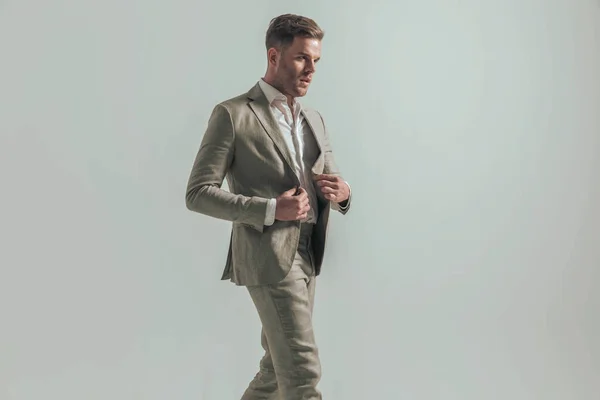 Sexy Man Undone Shirt Looking Side Buttoning Suit While Walking — стоковое фото