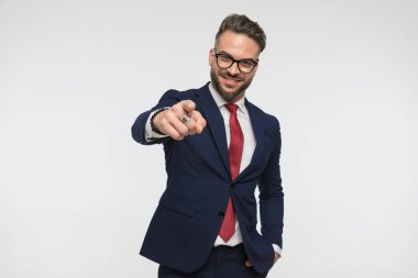 Stüdyoda beyaz arka planda el ele tutuşup gülümseyen gözlüklü çekici genç adam.