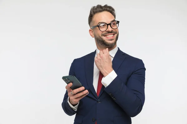 Glad Affärsman Elegant Kostym Innehav Telefon Tittar Bort Och Ler — Stockfoto