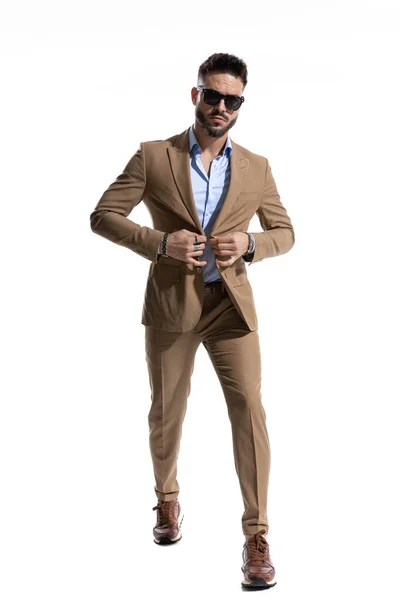 Bearded Young Man Sunglasses Buttoning Brown Suit While Walking Isolated — Stock Photo, Image