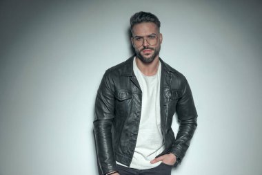 Çok erkeksi bir vücudu olan yakışıklı sıradan bir adam bir eli cebinde poz veriyor. 