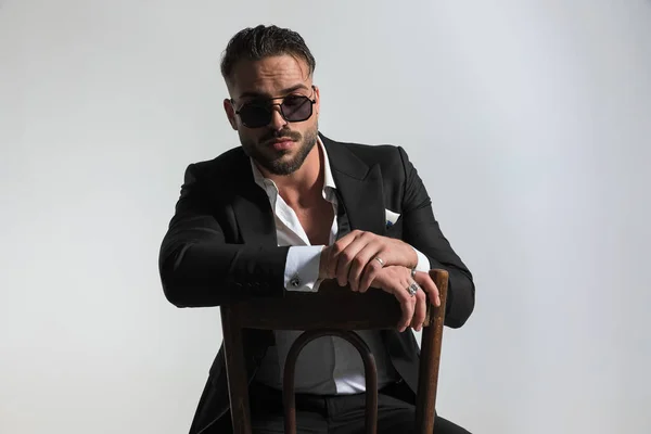 Portrait Sexy Man Open Collar Shirt Sunglasses Holding Arms Chair — Stock Photo, Image