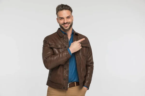 Retrato Homem Bonito Jaqueta Couro Marrom Apontando Dedo Para Lado — Fotografia de Stock