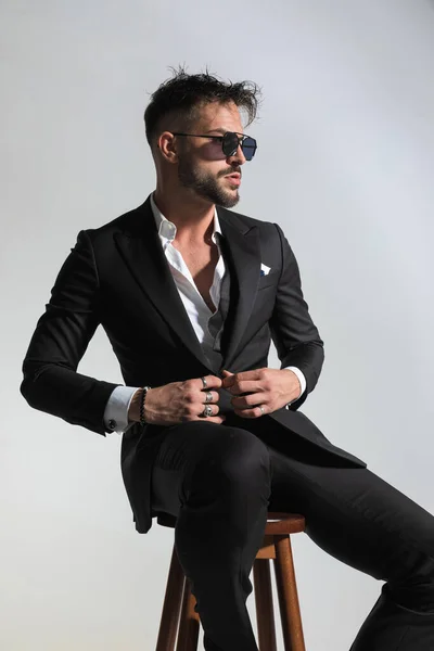 Cool Man Sitting Wooden Chair Buttoning His Tuxedo While Looking — Stock Photo, Image