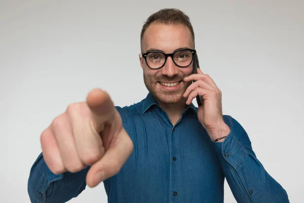 Attractive Casual Man Pointing Finger Talking Phone Wearing Blue Shirt — Stock Photo, Image