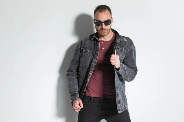 Cool Fashion Guy Sunglasses Pulling Adjusting Grey Denim Jacket Posing — Stock Photo, Image