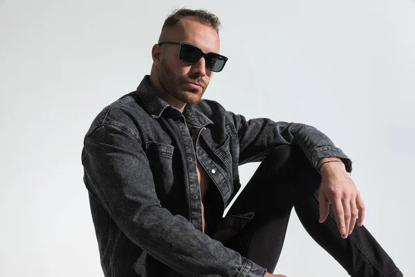 Casual Hombre Sentado Chaqueta Mezclilla Gris Con Gafas Sol Posando — Foto de Stock