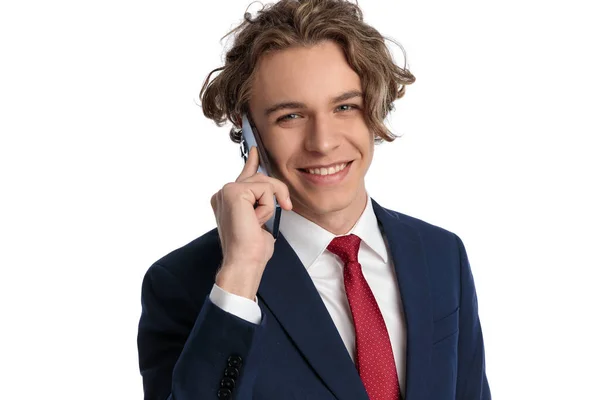 在演播室里 一个金发碧眼 一头卷曲长发的男人在电话中交谈 在白色背景前微笑的画像 — 图库照片