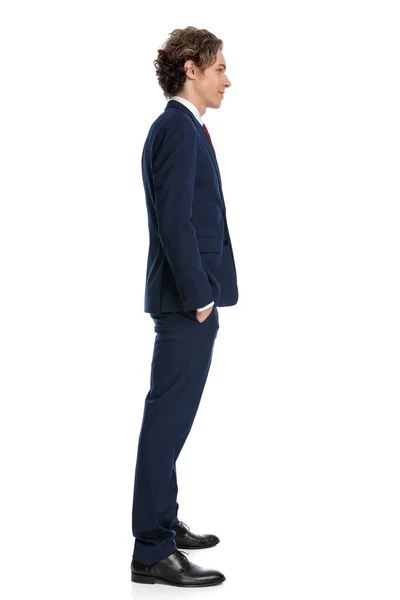 スタジオの白い背景の前でポケットに手を取り並んで待っている長い髪を持つエレガントなビジネスマン — ストック写真