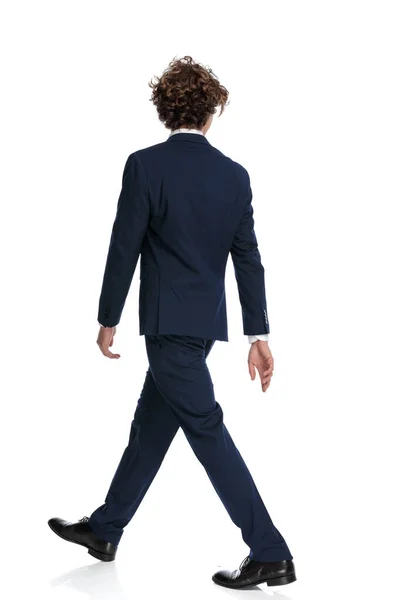 Stüdyoda Beyaz Arka Planda Yürüyen Kıvırcık Saçlı Genç Adamının Arka — Stok fotoğraf