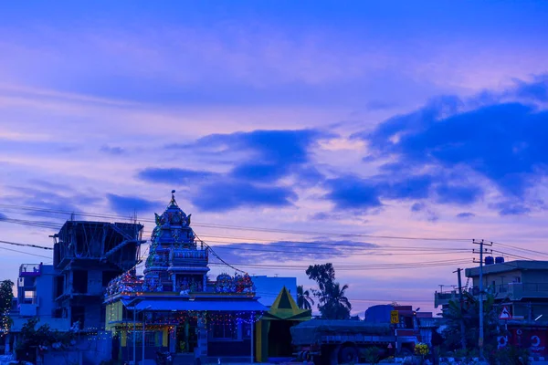 Sunrise over a India against a striking blue sky with random buildings in the background. Can be used as a presentation slide.