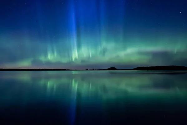 Scenic view of northern lights over calm lake in Sweden (Aurora borealis)