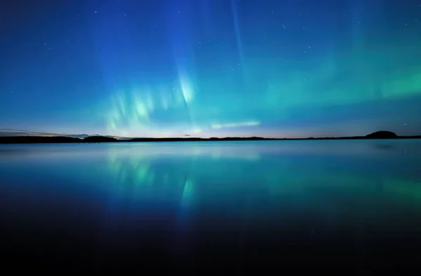 Scenic view of northern lights over calm lake in Sweden (Aurora borealis)