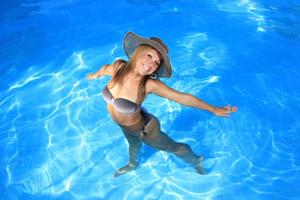 Jovem mulher desfrutando de uma piscina — Fotografia de Stock