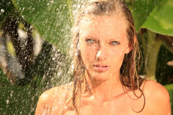 Vrouw in tropische douche palmen rond — Stockfoto