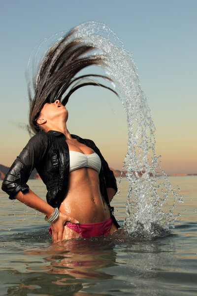 girl splashing the sea water with her hair
