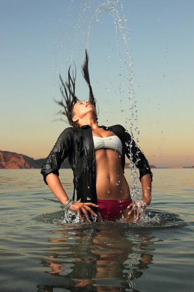 girl splashing the sea water with her hair