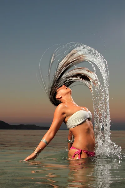 Κορίτσι που καταβρέχει το νερό της θάλασσας με τα μαλλιά της — Φωτογραφία Αρχείου