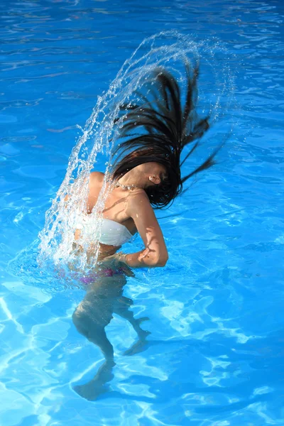 Uma bela mulher relaxando na piscina — Fotografia de Stock