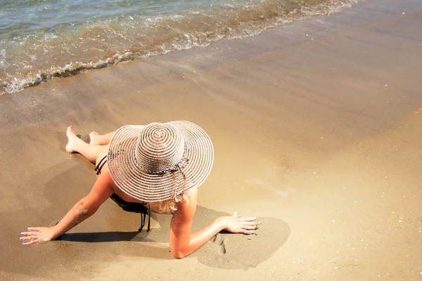 Kız şapka ile tropikal bir plajda — Stok fotoğraf