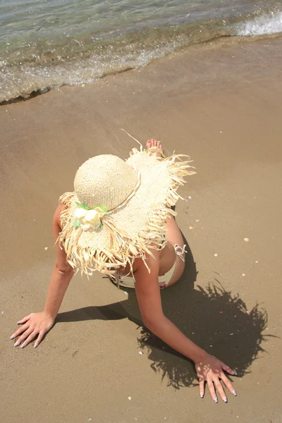 Girl on a tropical beach with hat — Stock Photo, Image