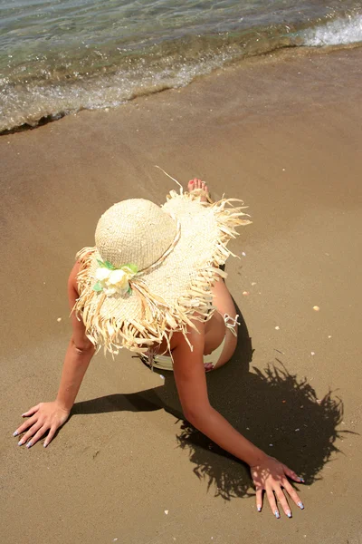 Flicka på en tropisk strand med hatt — Stockfoto