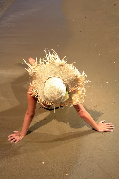 Flicka på en tropisk strand med hatt — Stockfoto