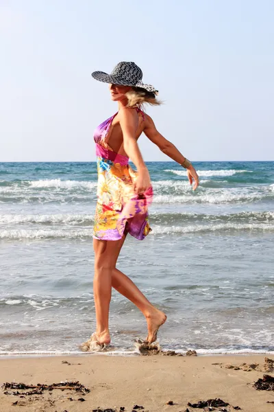 Jonge vrouw in jurk en stro hoed — Stockfoto