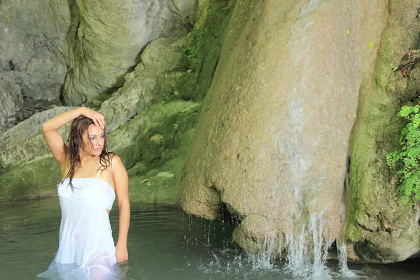 Meisje in witte jurk genieten van een waterval — Stockfoto