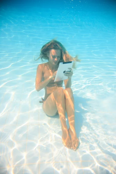 Vrouw met tablet pc onderwater — Stockfoto