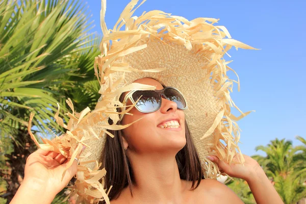 Schoonheid portret van vrouw op het strand dragen stro hoed — Stockfoto