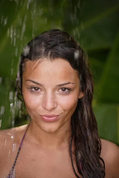 Kobieta w prysznic tropikalny dłonie wokół — Zdjęcie stockowe