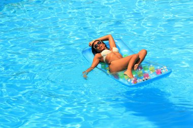 Havuzda dinlenen bir kadın.