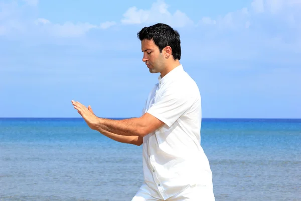 Handsome man on the beach meditating — Stock Photo, Image