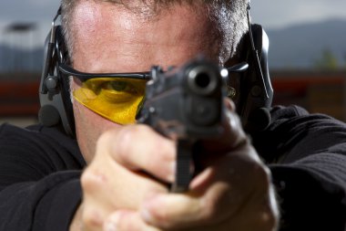 Man shooting on an outdoor shooting range clipart