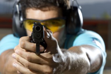 Man shooting on an outdoor shooting range clipart