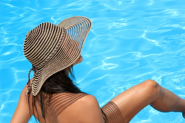 Vrouw zitten op de rand van het zwembad. — Stockfoto