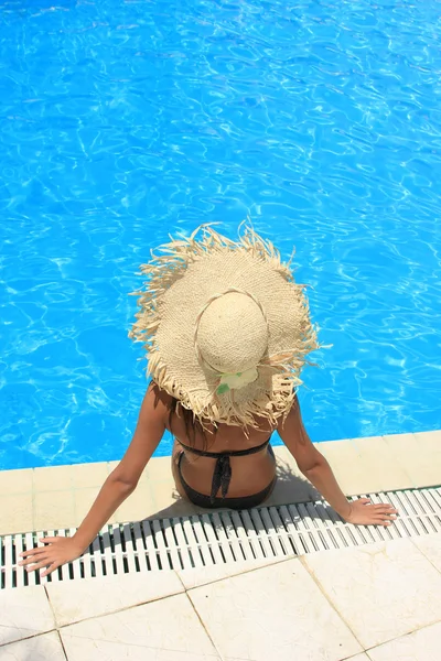 Mulher sentada na borda da piscina . — Fotografia de Stock